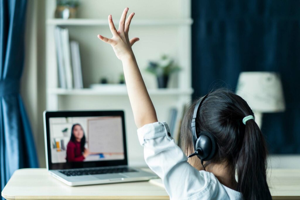 Young girl participating in online learning via a laptop